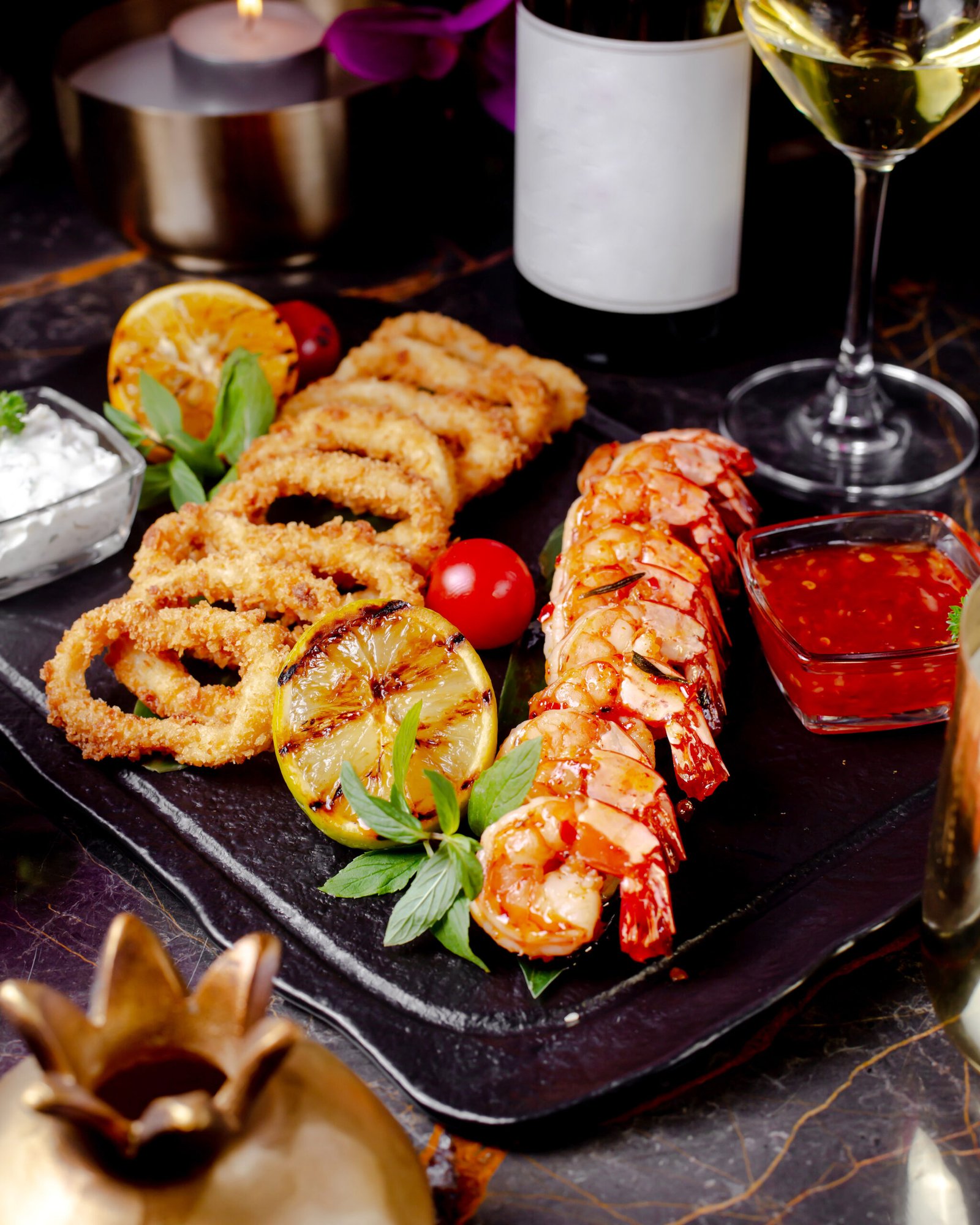 scrimps and onion rings served with sauce and lemon